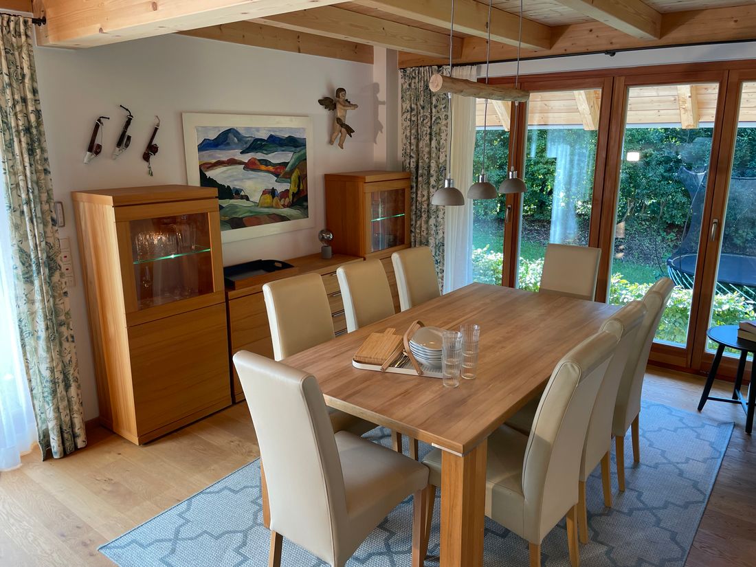 Esszimmer mit Holztisch für 8 Personen und Blick auf den Garten