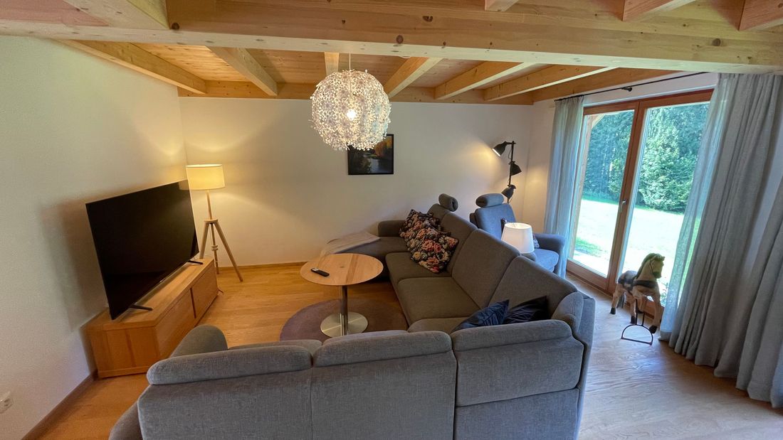 Wohnzimmer mit Eichenparkett, Smart TV und einer Leseecke zum Entspannen