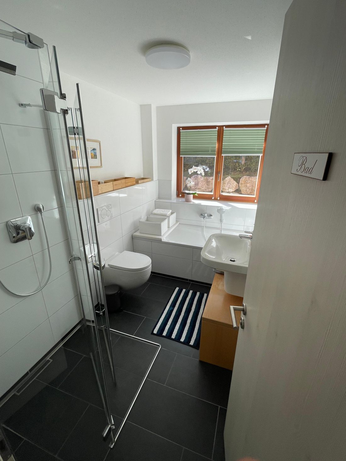 Bad 1 im Untergeschoss mit bodentiefer Dusche und Badewanne