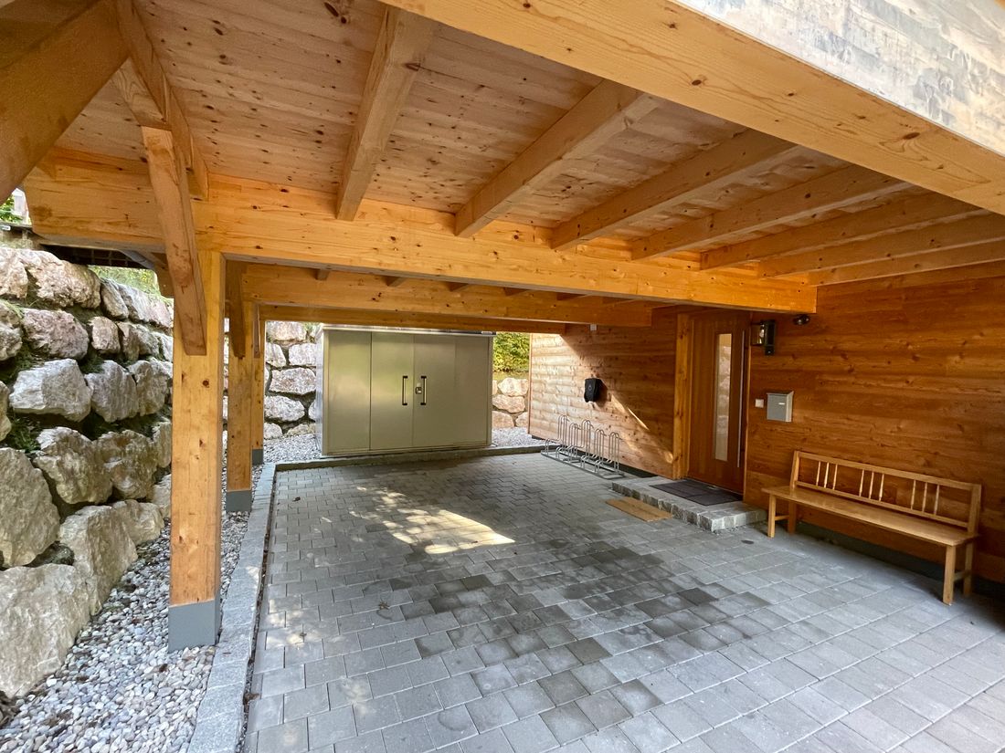 Car Port unter der Holzterasse mit Wallbox für E-Autos.